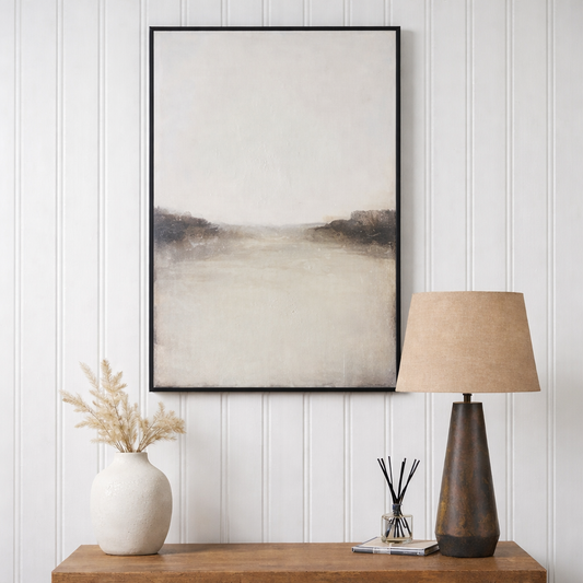 Framed abstract art on a wall above a wooden console table with decorative items.